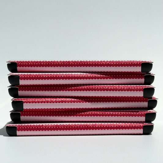 Close-up of six Cherry Ledger Kindle case spines in shimmering cherry red and pink