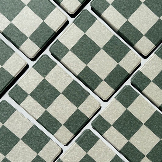 Flatlay of Forest Lore Kindle cases in a diagonal grid showing green and cream checkerboard pattern