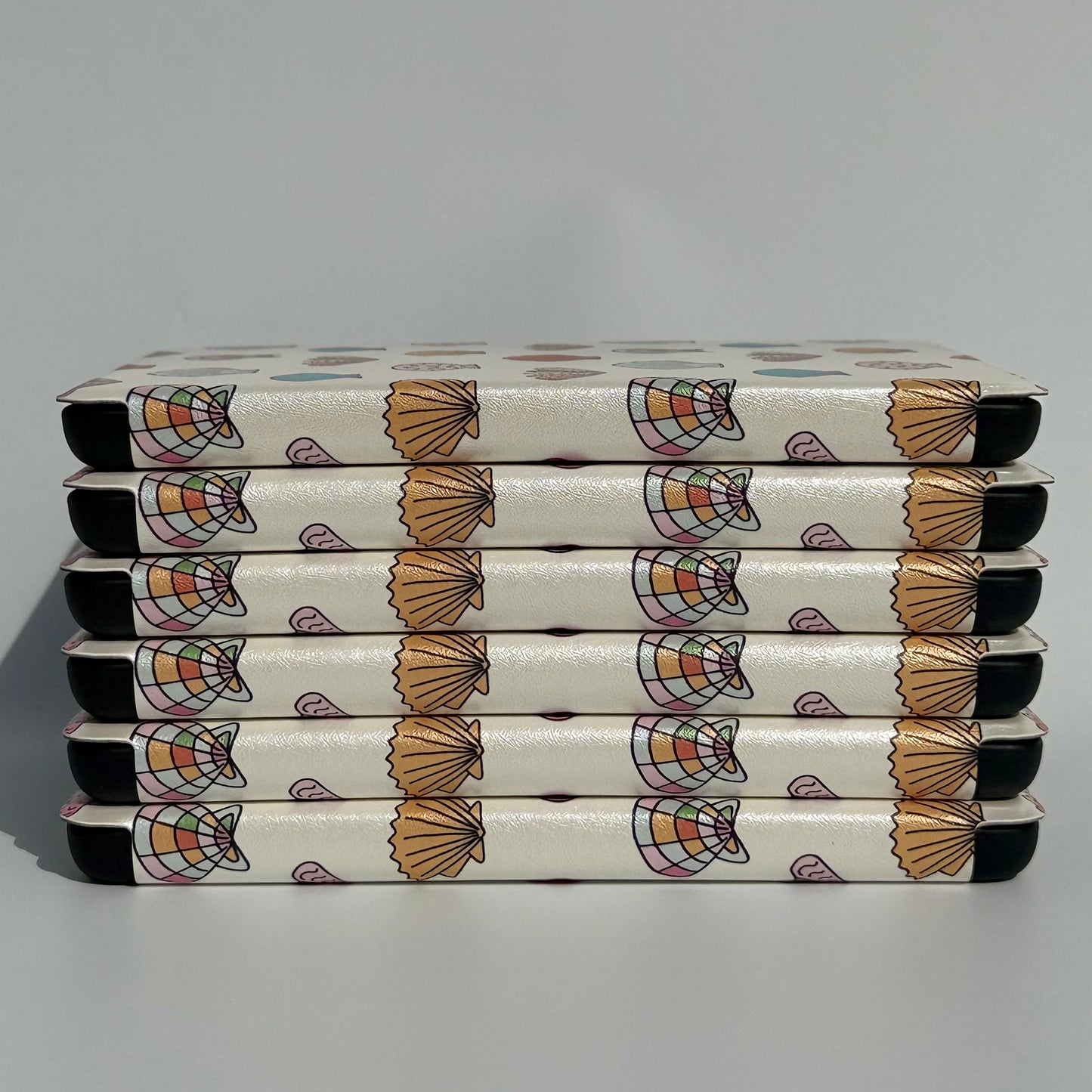 pastel kindle cases stacked on white background