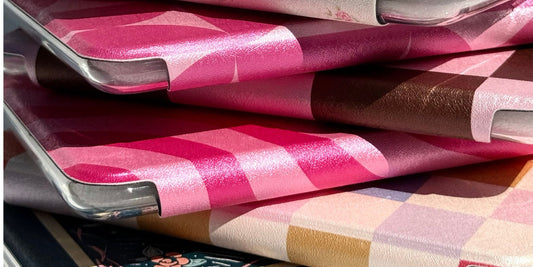 Stack of illustrated Kindle cases in pink and checkered prints by Case Society Co