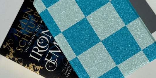 A blue gingham e-reader case beside a dark fantasy hardback, from Case Society Co in Australia.