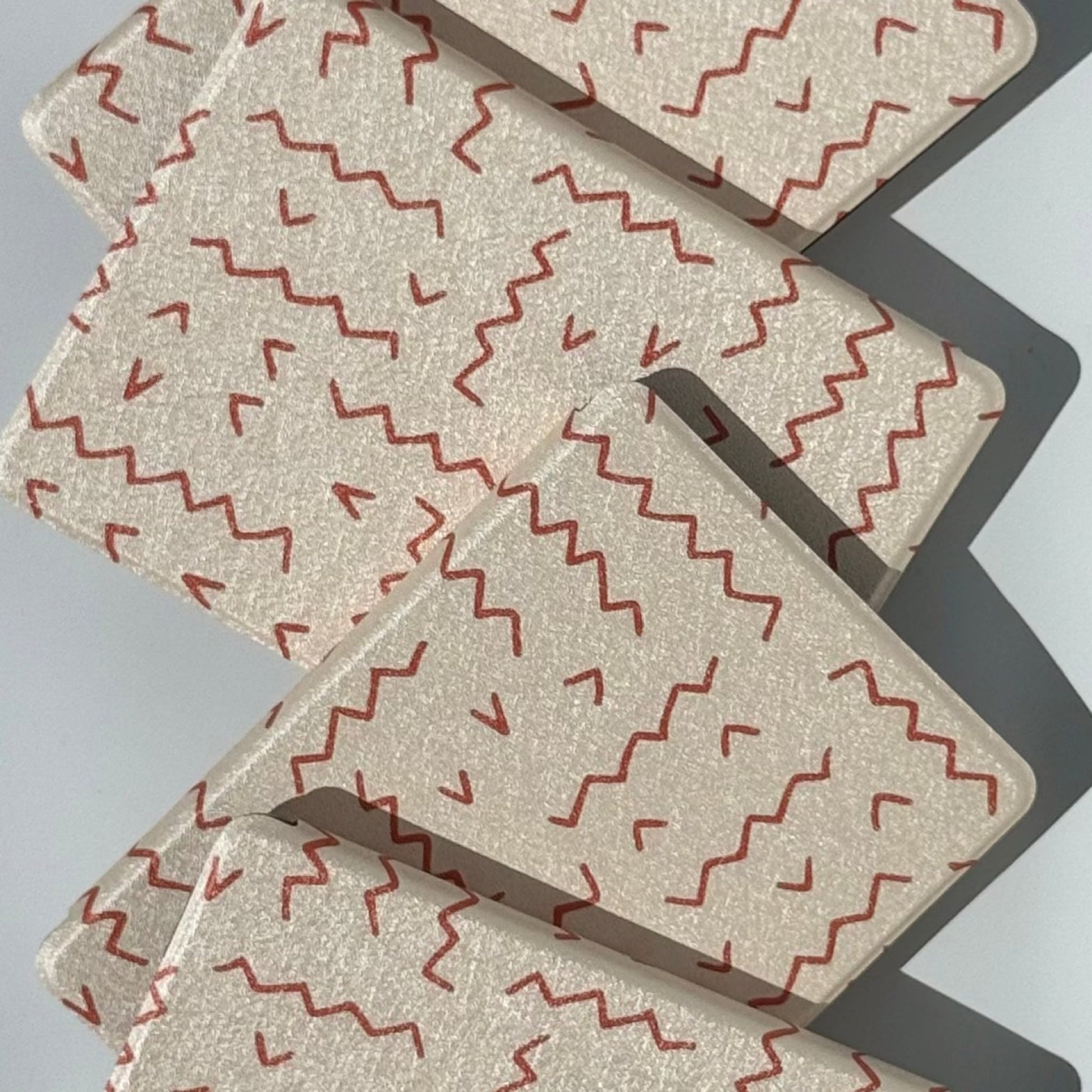 Between The Lines Kindle case, hand-drawn red squiggles on warm oatmeal, artistic aesthetic Kindle cover