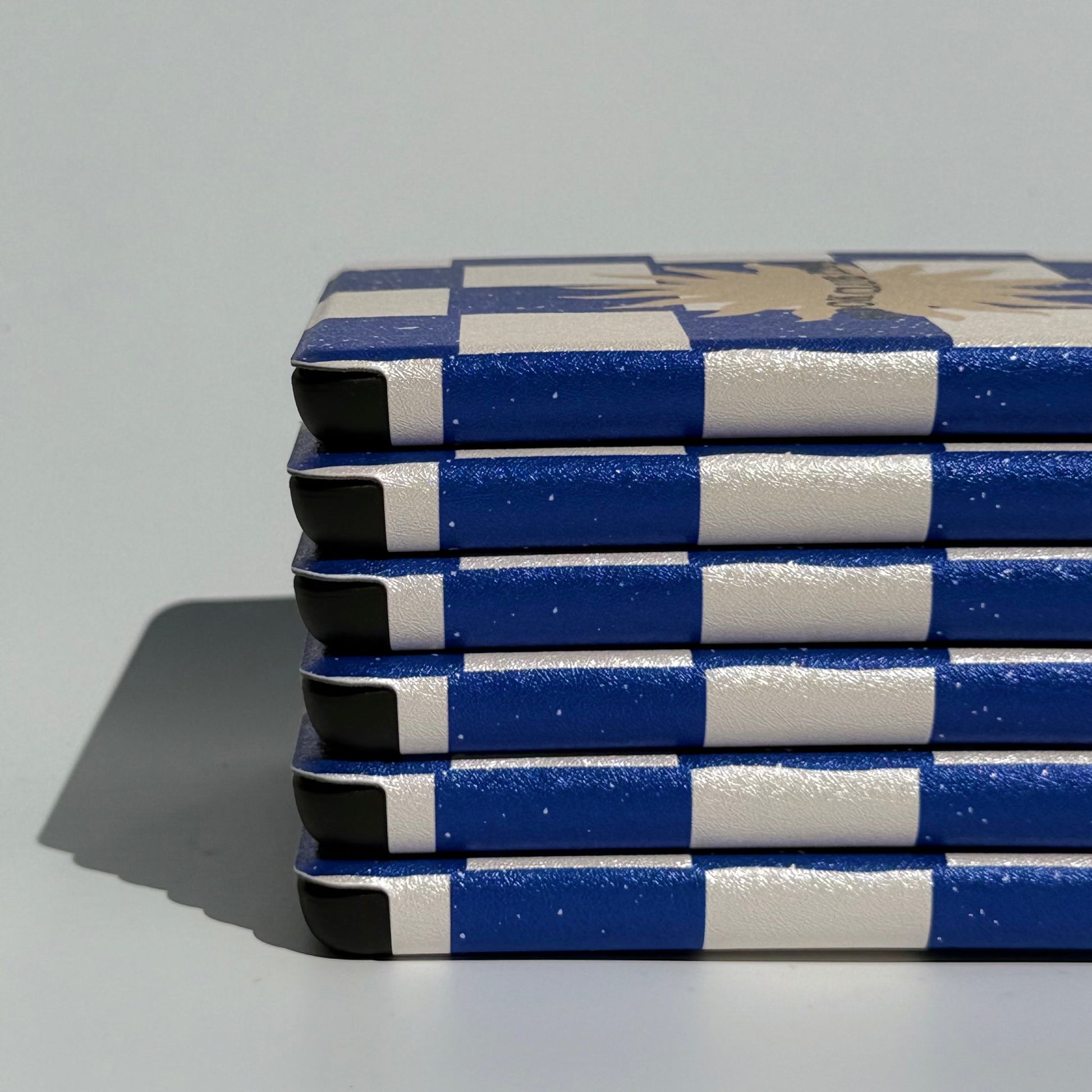 Book Club Era navy checkerboard Kindle case with gold sun and hand strap