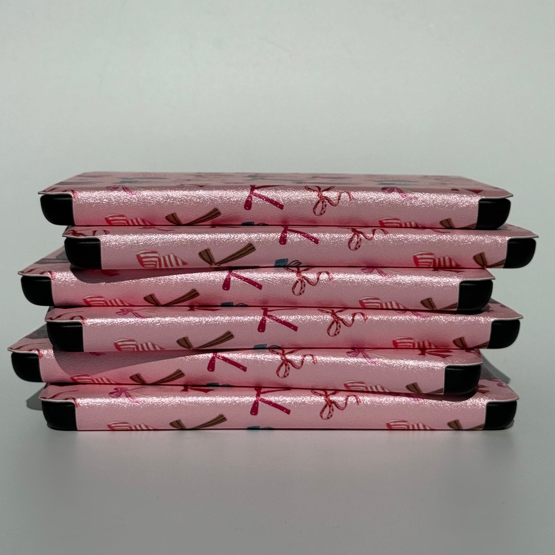 stack of pink kindle cases on a white background