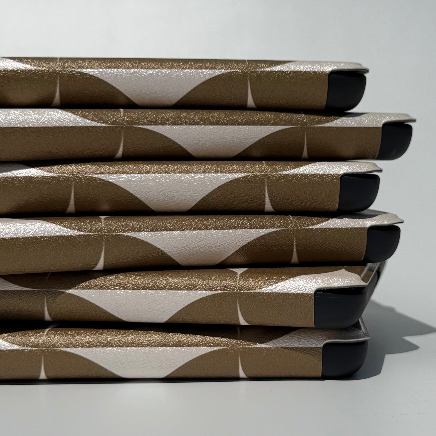 Case Society Olive Chip Kindle Case - close up spine view of stack of cases