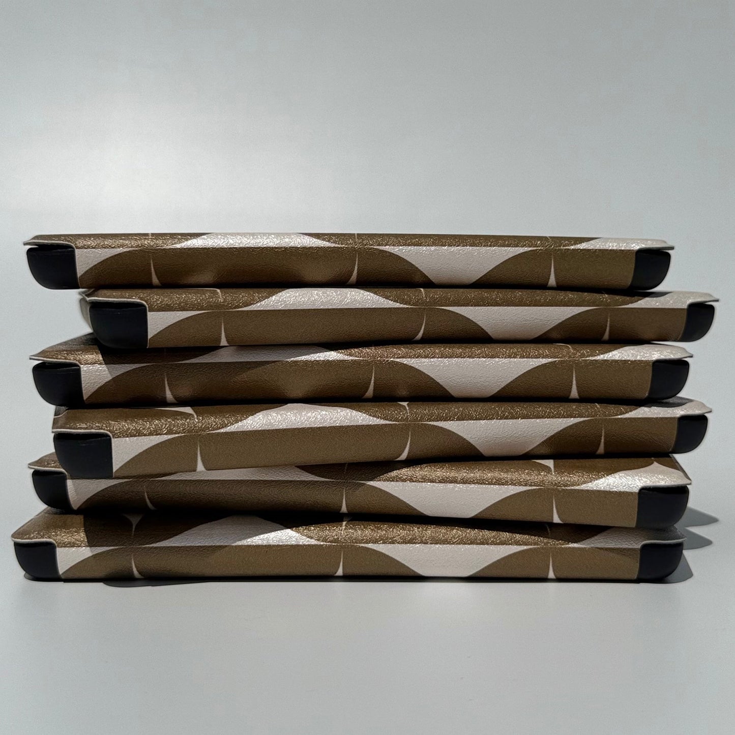 Spine view of stacked Olive Chip olive geometric Kindle cases