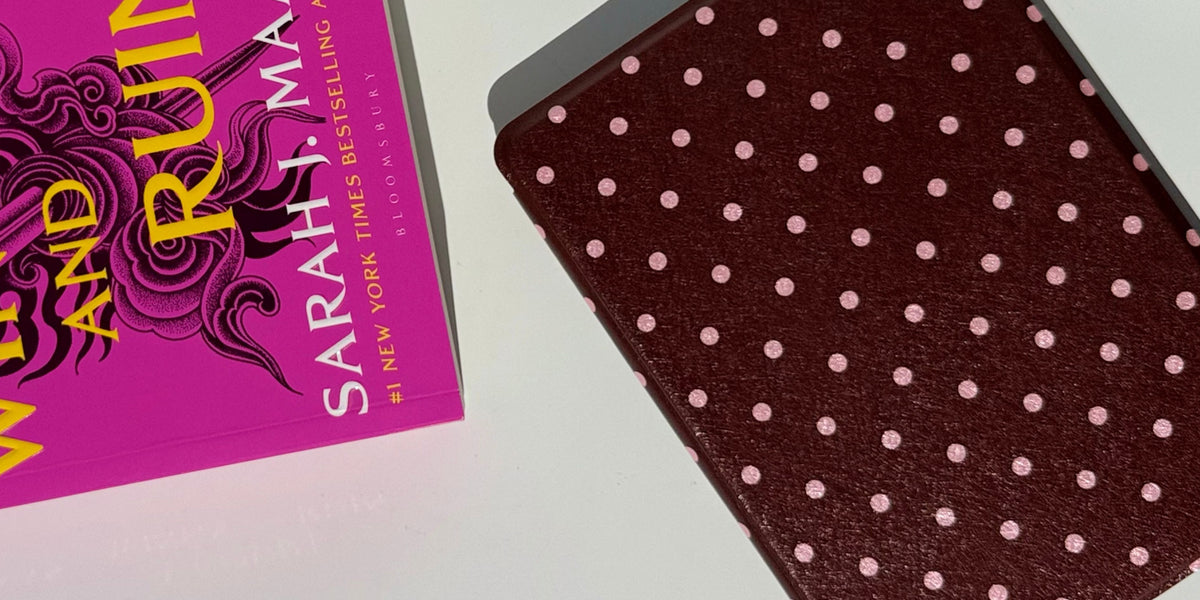 Cocoa Kiss polka dot Kindle case styled beside a pink fantasy paperback, from Case Society Australia