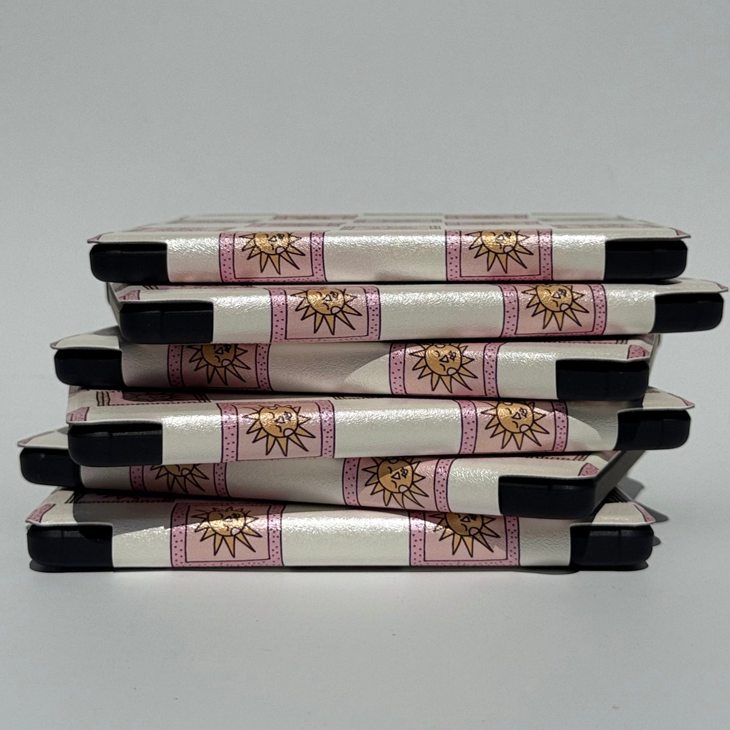 Stack of pink and white kobo cases with handstrap