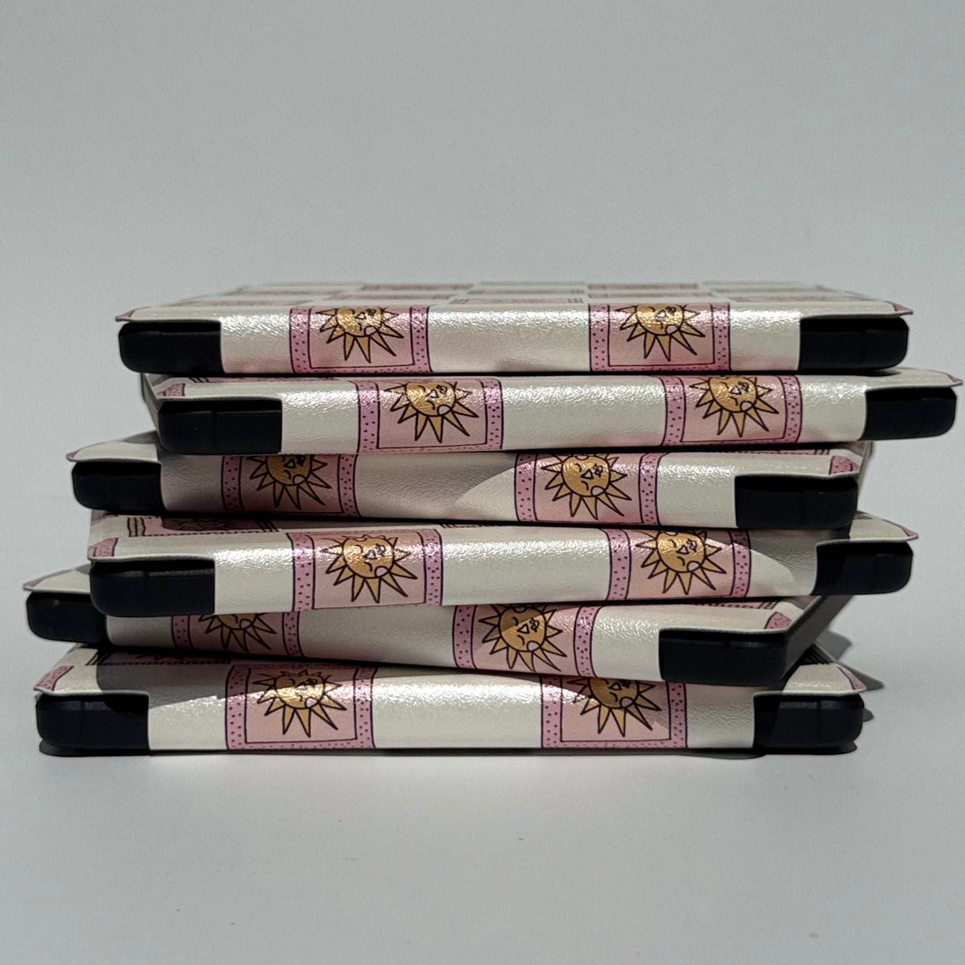 Stack of pink and white kobo cases with handstrap