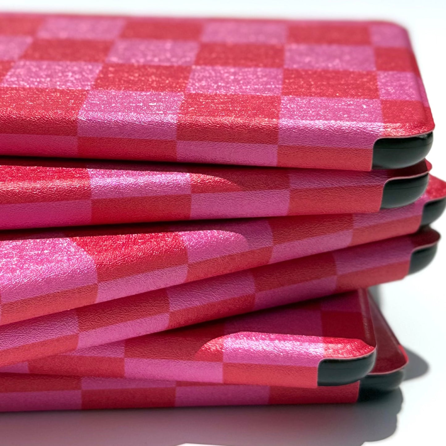 Side profile of stacked pink and red checkered Kindle cases, Love's Bouquet by Case Society
