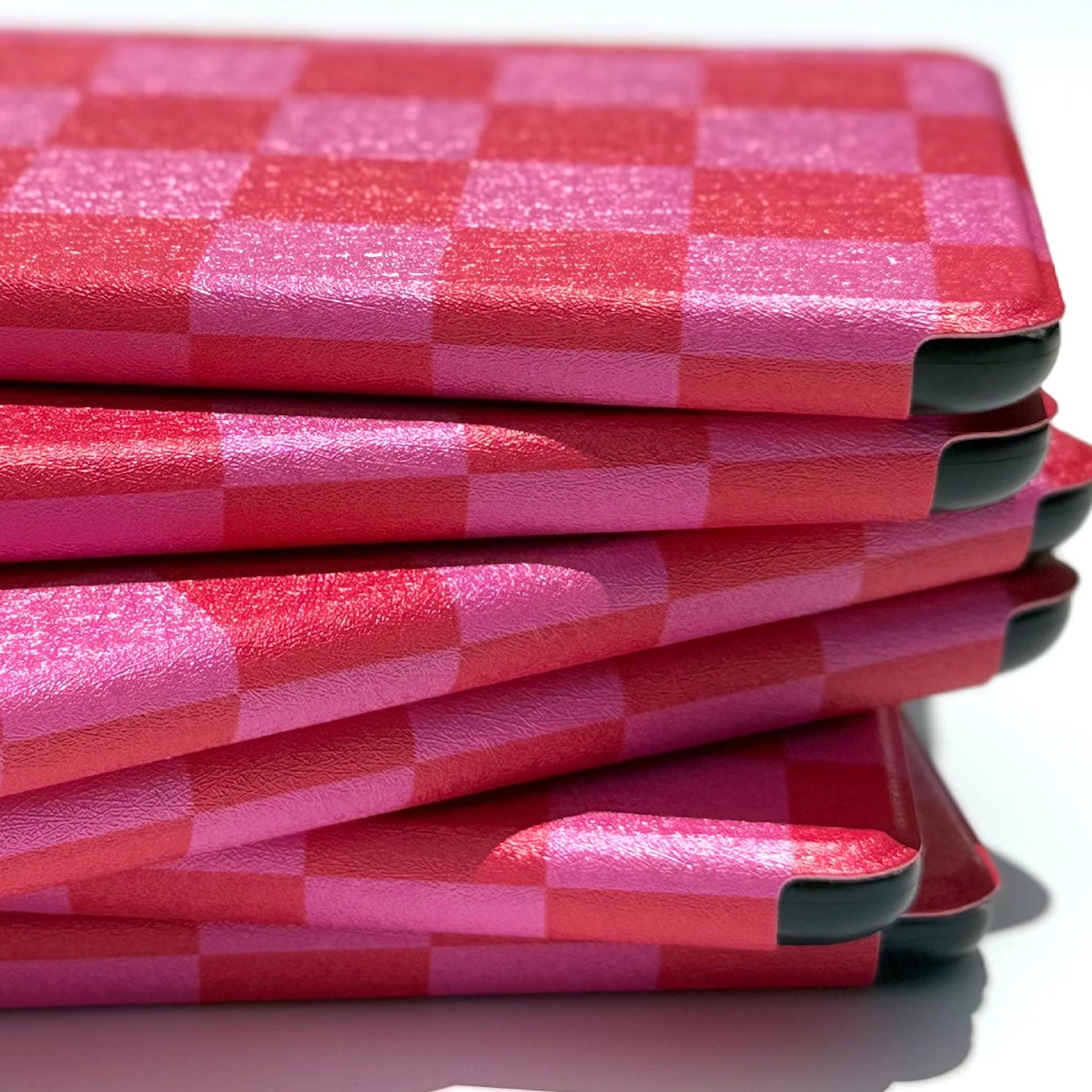 Side profile of stacked pink and red checkered Kindle cases, Love's Bouquet by Case Society