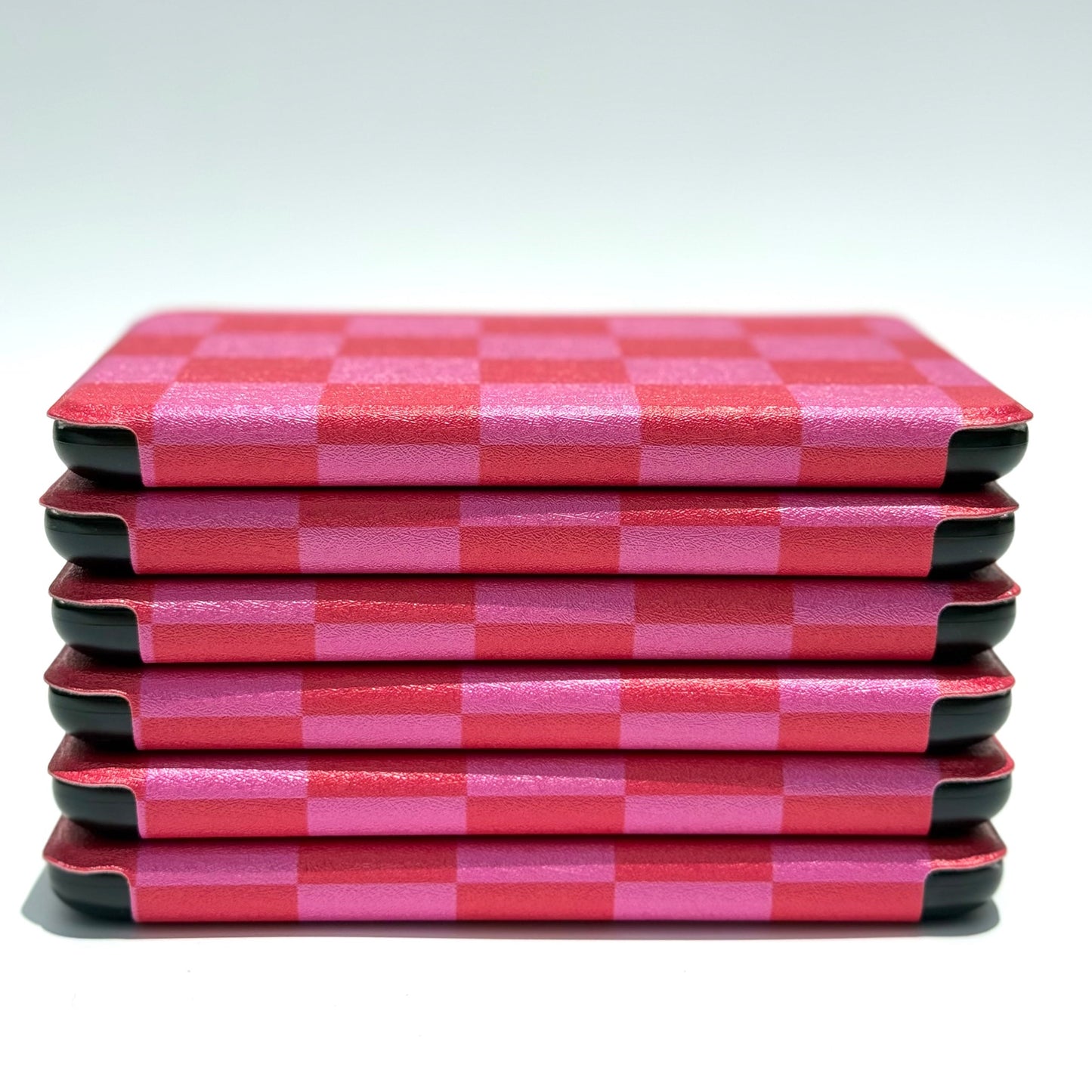 Edge profile of Love's Bouquet Kindle case stack showing slim pink and red checkered design