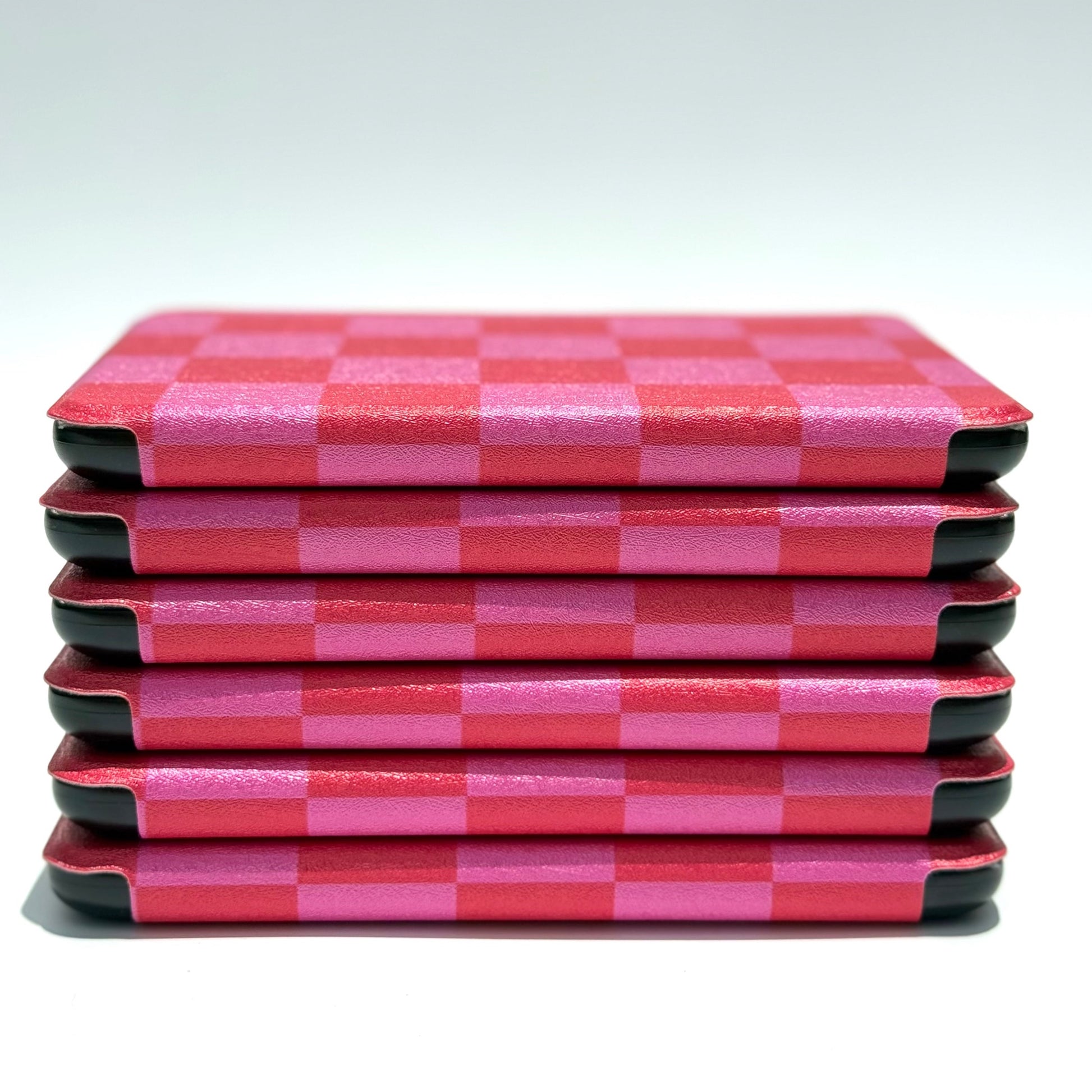 Edge profile of Love's Bouquet Kindle case stack showing slim pink and red checkered design