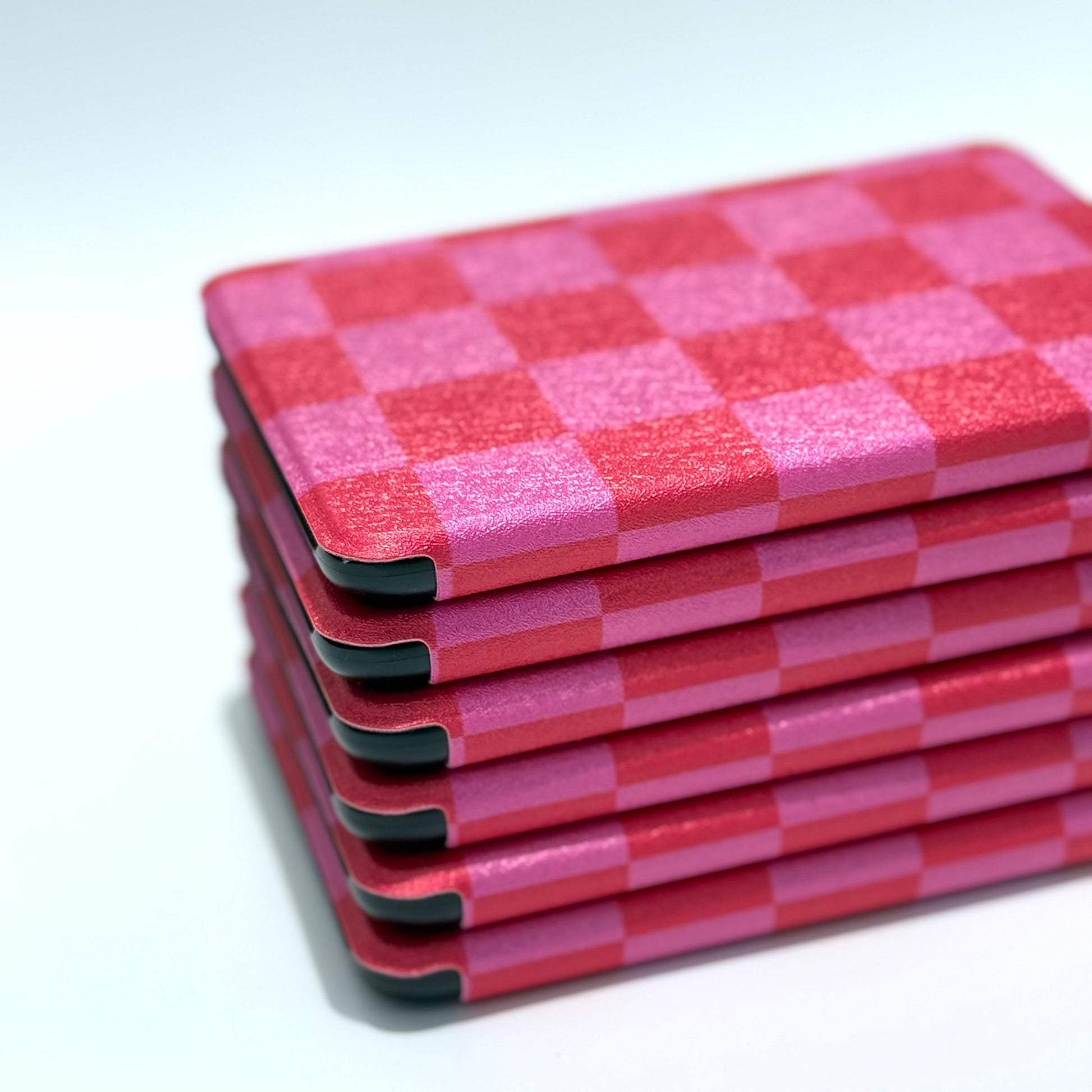 Stack of slim Love's Bouquet Kindle cases lying flat, pink and red checkered Case Society Australia