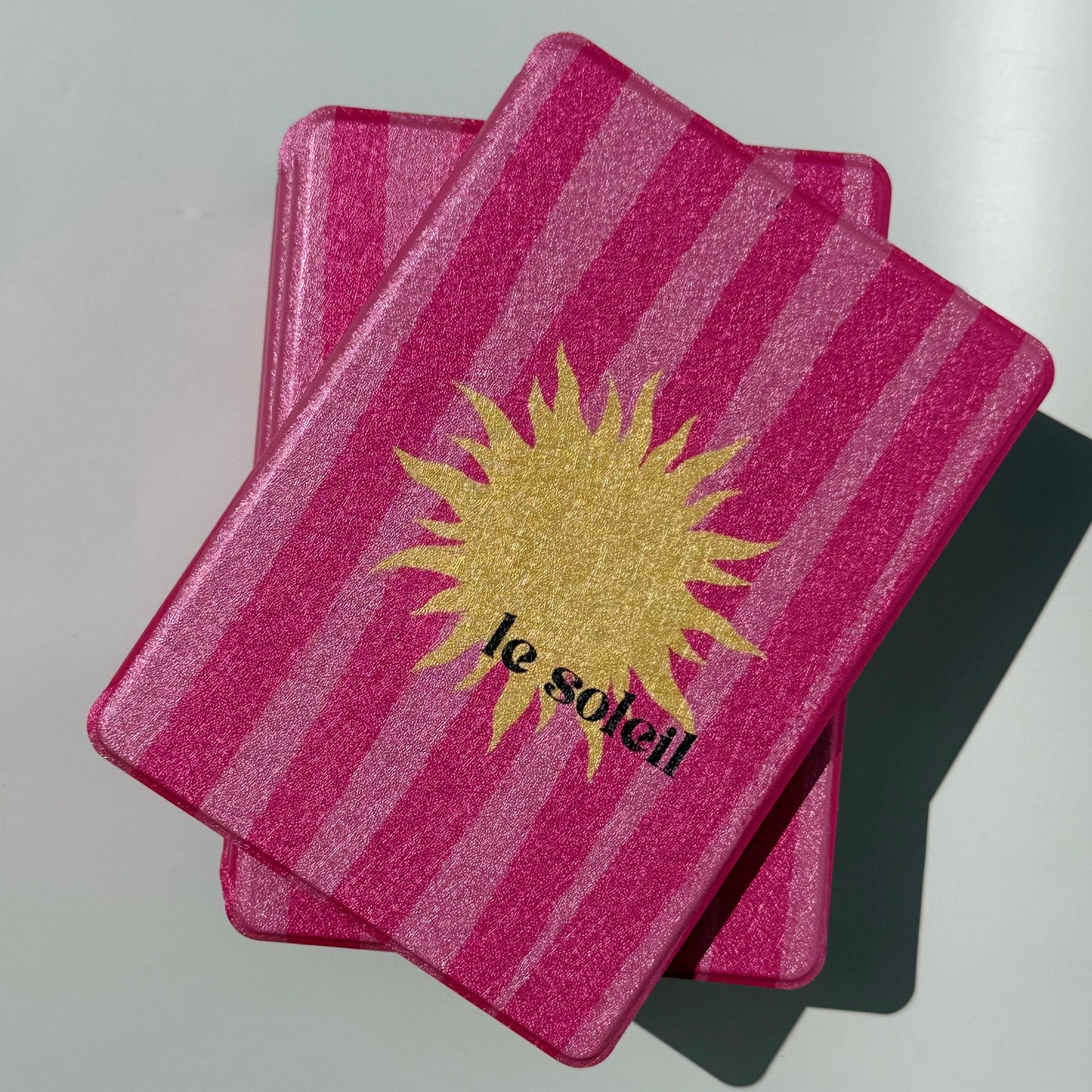 Front view of the Le Soleil Kindle case, raspberry pink stripes with a golden sun