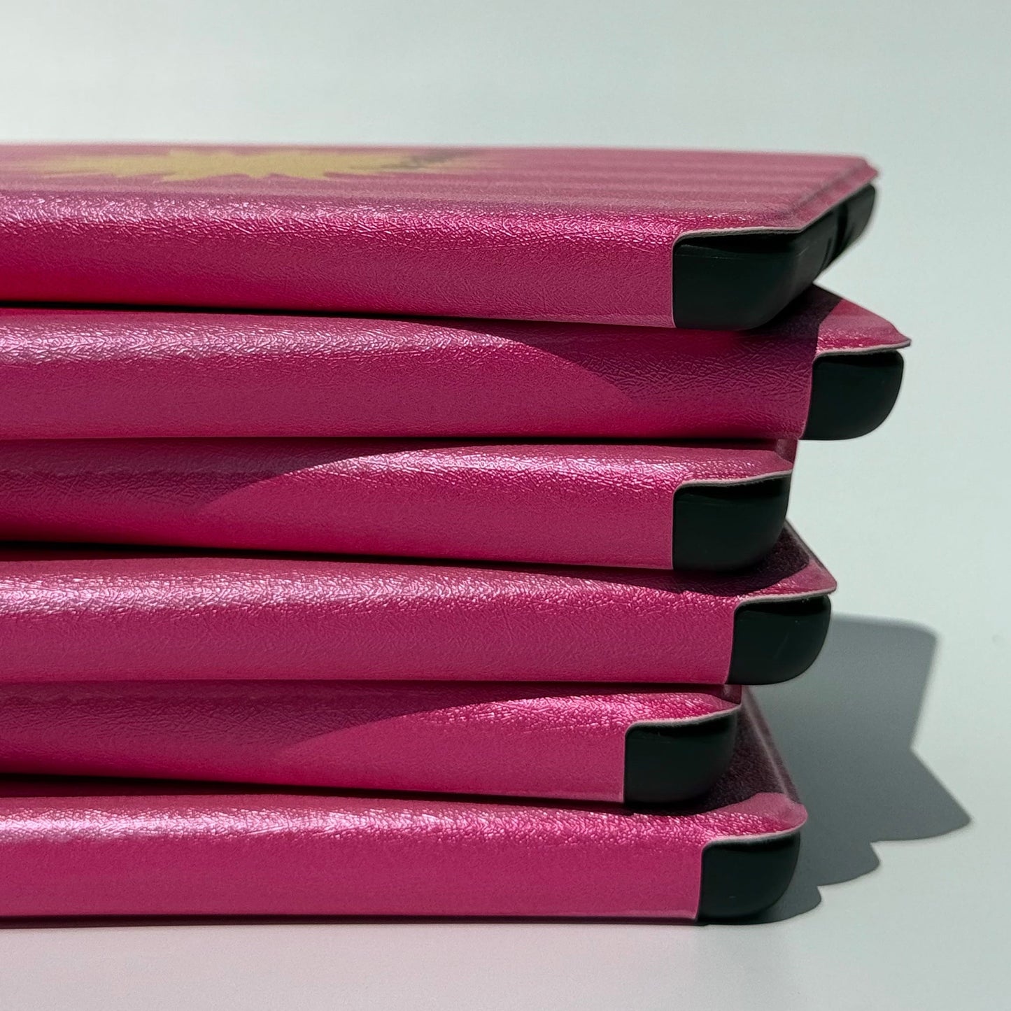 Close-up side view of the Le Soleil pink striped Kindle case