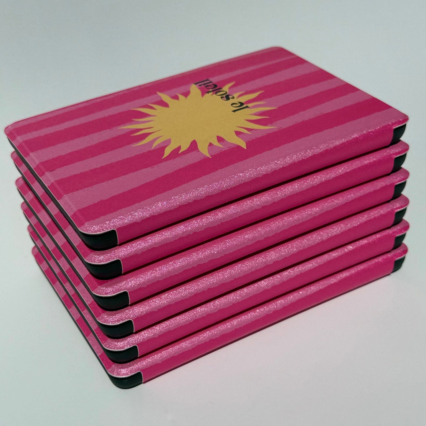 Le Soleil pink striped Kindle cases showing the front sun and spine edges