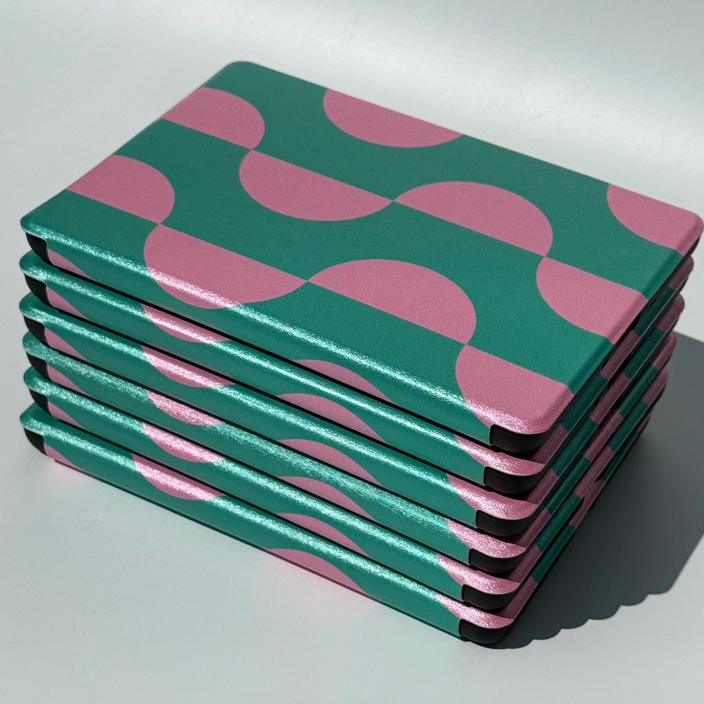 Side stack of Pink Crescent green and pink Kindle cases showing the slim profile
