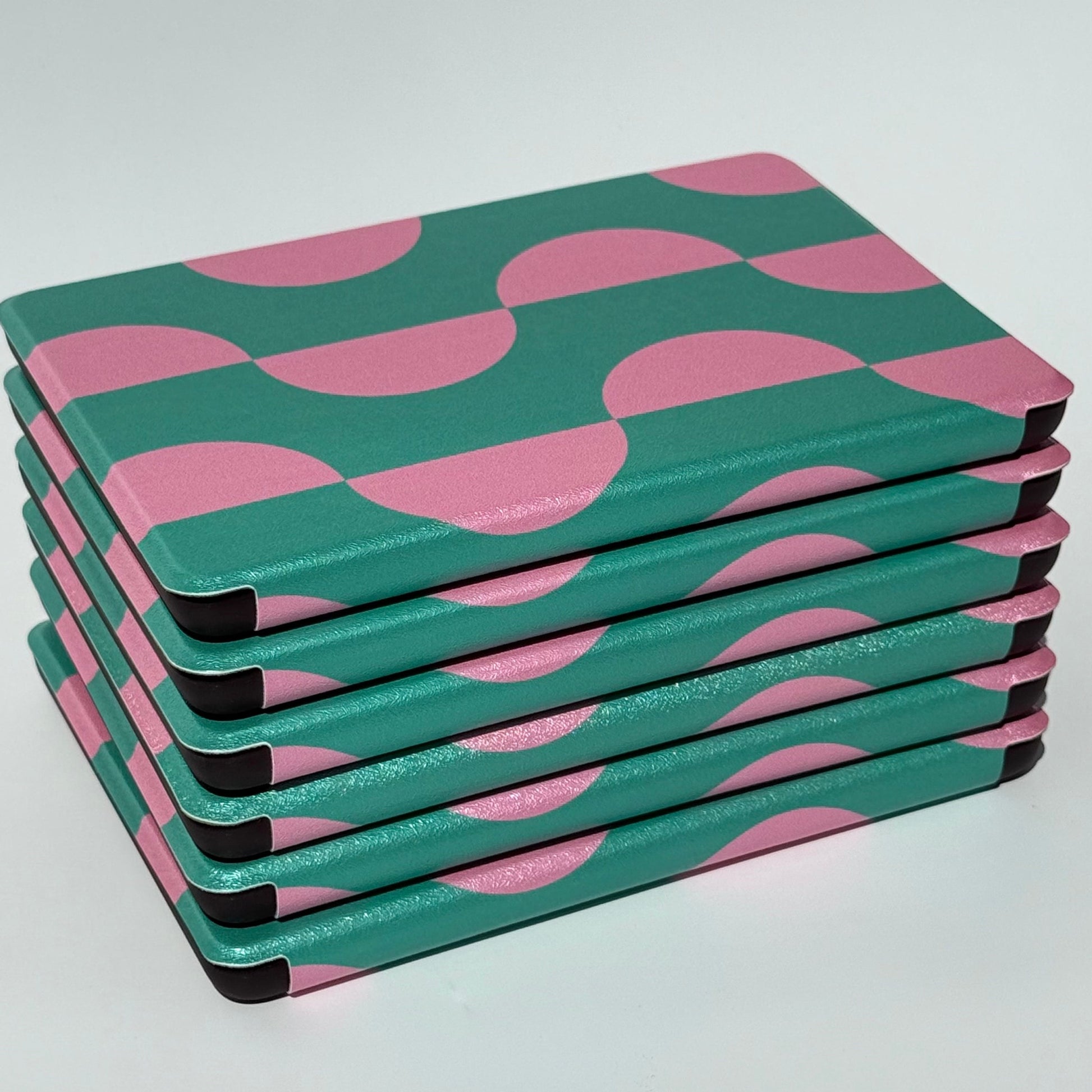 Stack of Pink Crescent green and pink Kindle cases from the side