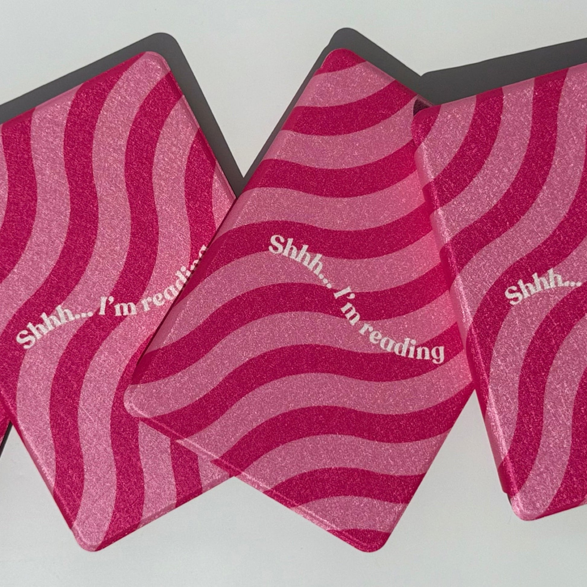 Top view of Shhh I'm Reading pink wavy Kindle case with hand strap