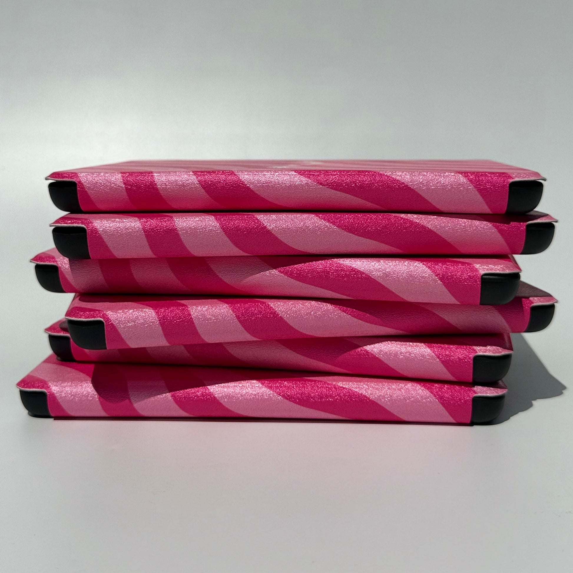 Side stack of Shhh I'm Reading pink wavy stripe Kindle cases