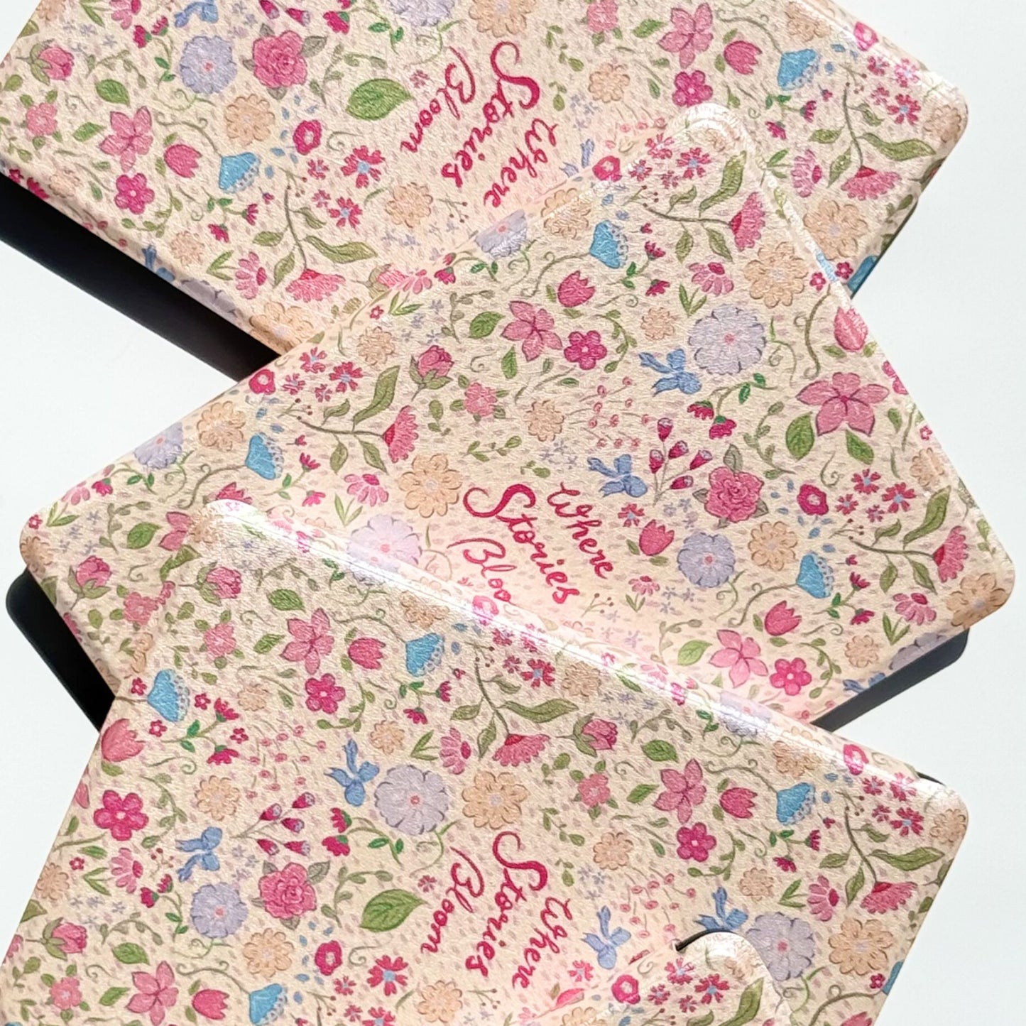 Pink floral Kindle Paperwhite case with vintage wildflower pattern and "Where Stories Bloom" script