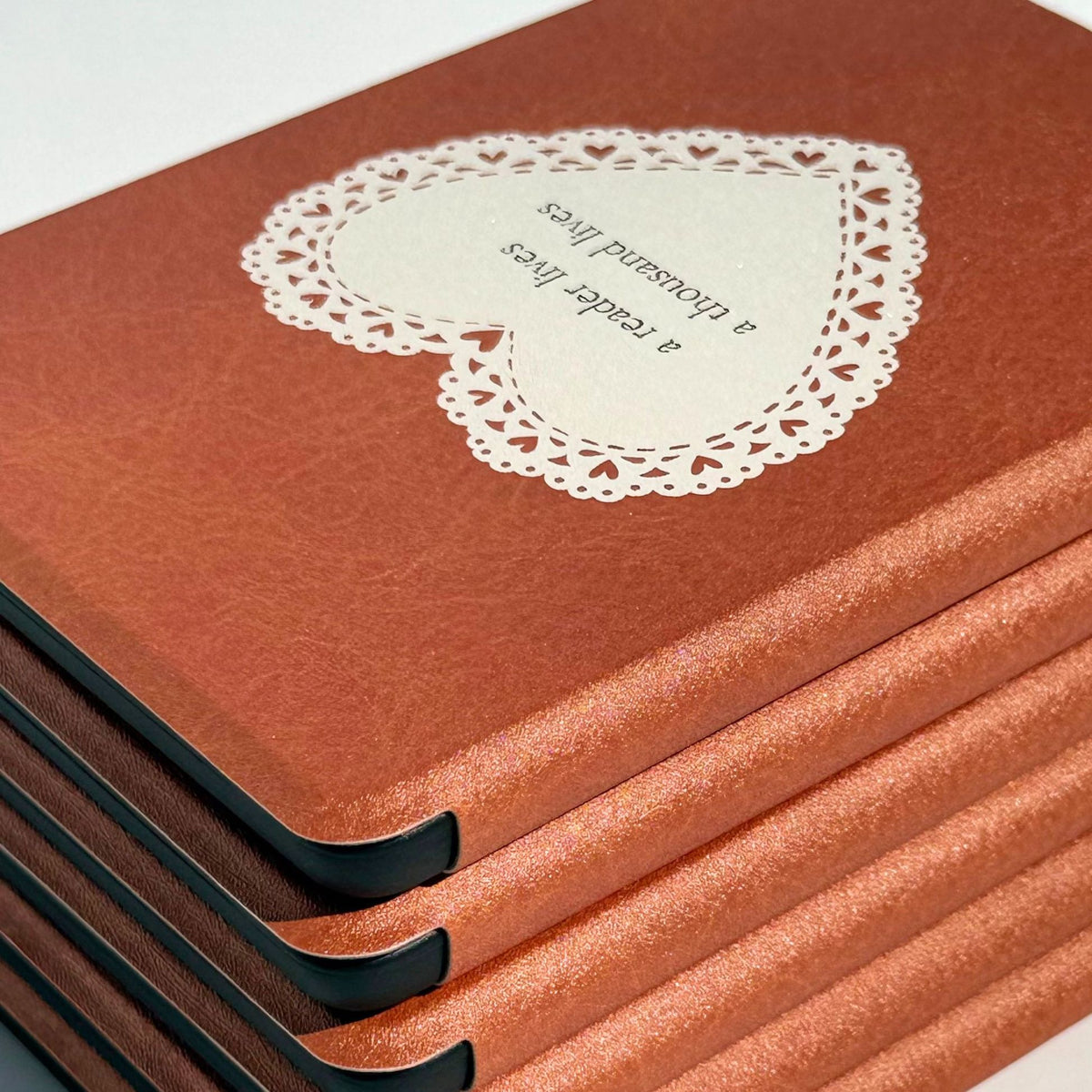 Stack of tan brown vegan leather Kindle cases with the lace heart on top, Case Society Co