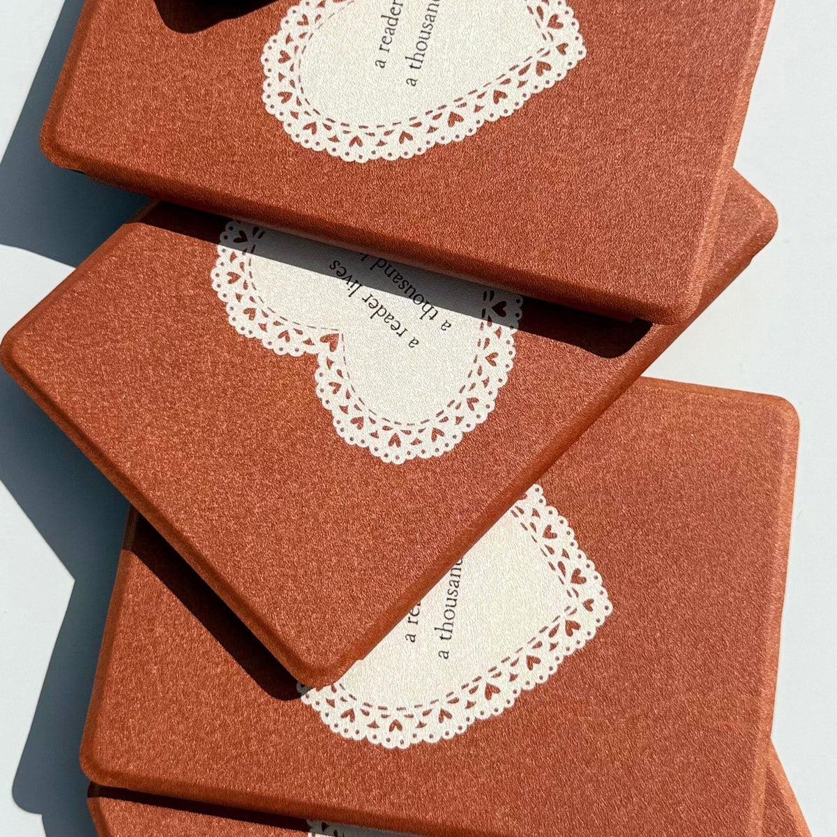 Stacked A Thousand Lives Kindle Paperwhite cases fanned at an angle