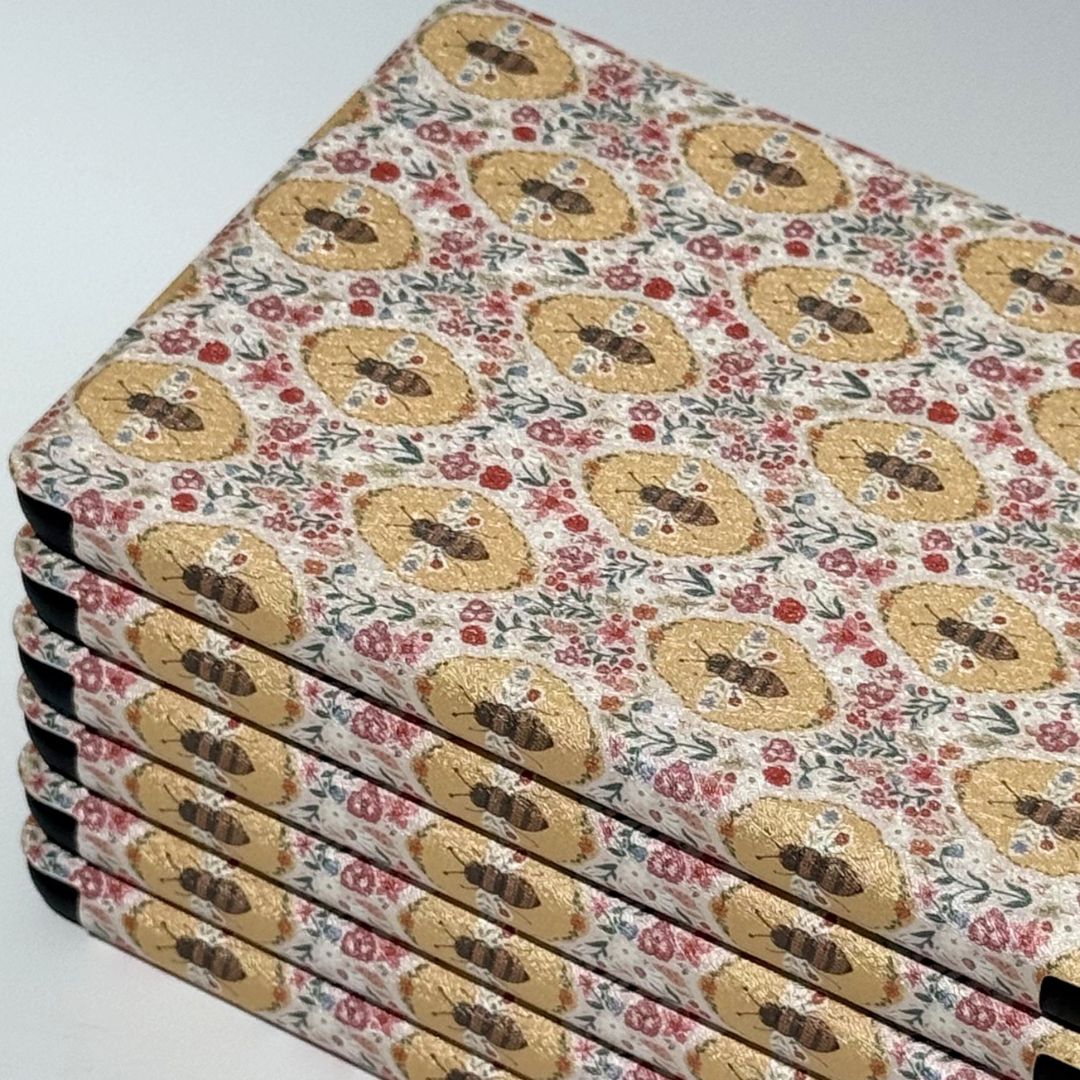 Beekeeper's Garden Kindle cases arranged in an aerial grid showing cottagecore golden bee and wildflower print