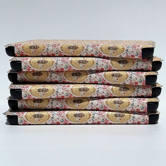 Stack of The Beekeeper's Garden Kindle cases showing vintage golden bee and wildflower pattern — aesthetic floral Kindle case