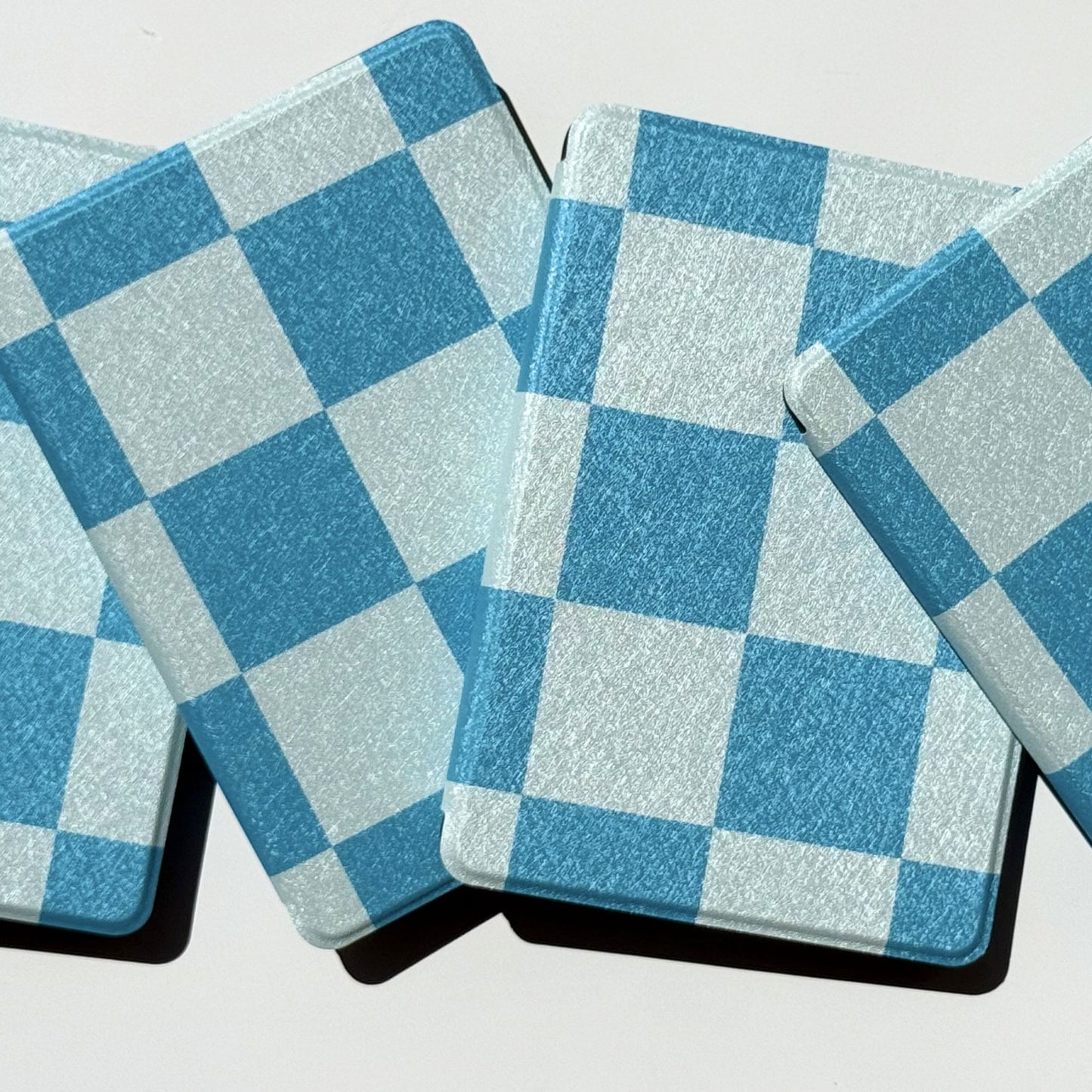Aesthetic blue check Kindle cases laid in a grid, shipped from Australia
