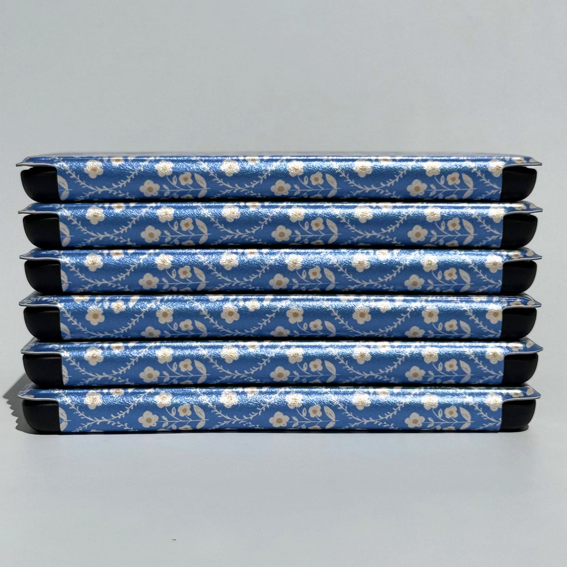 Bluebell Kindle cases stacked neatly, showing the cottagecore blue floral design — aesthetic Kindle case AU
