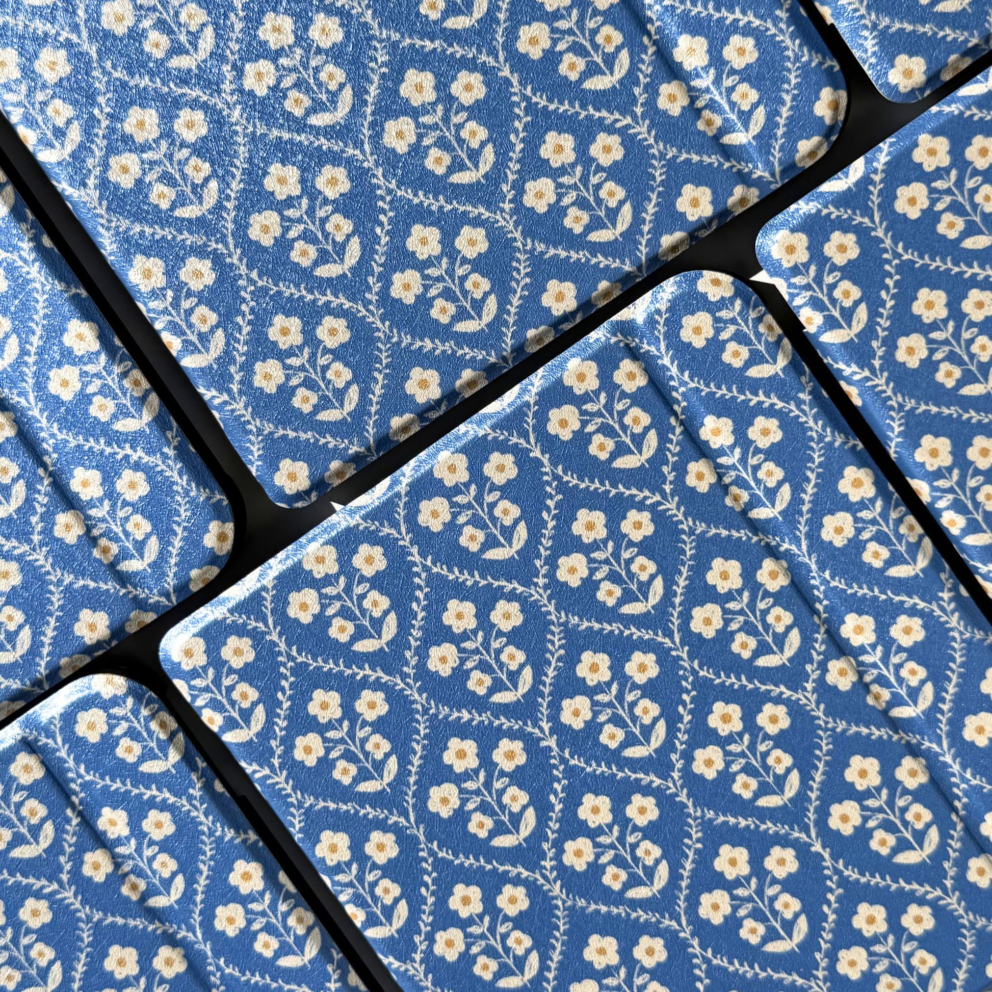 Close-up of the cream flowers and blue trellis on a Bluebell Kobo case, Case Society Co