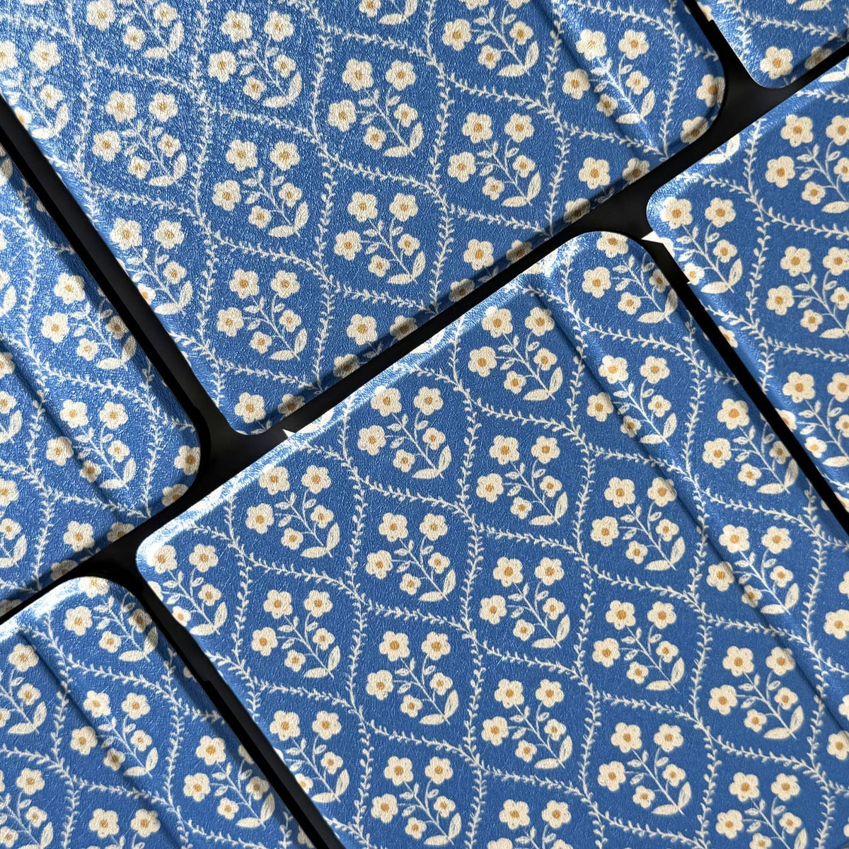 Close-up of the cream flowers and blue trellis on a Bluebell Kobo case, Case Society Co