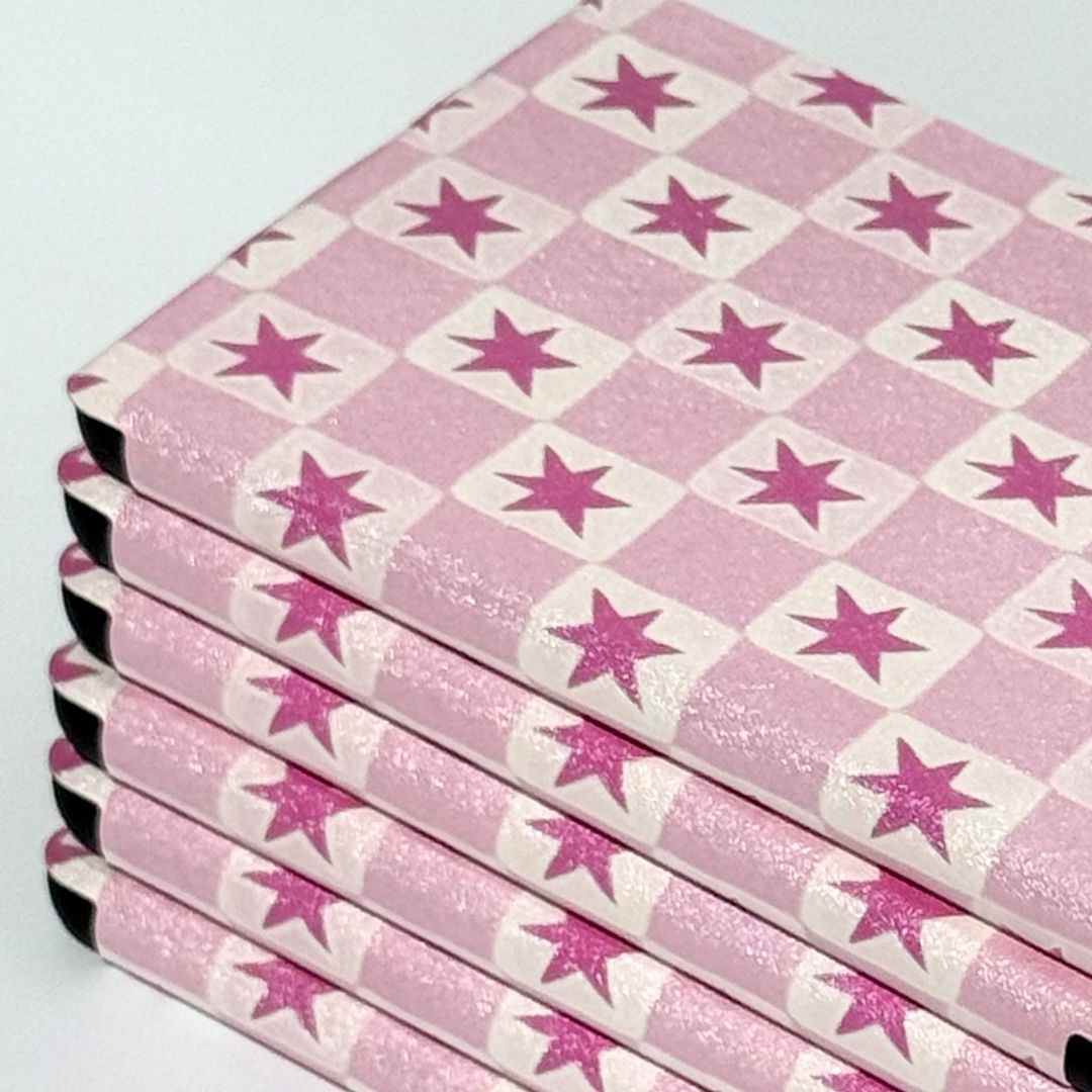 Stack of Blush Cosmos Kindle cases showing pink star checkered pattern with shimmer finish — aesthetic Kindle case AU