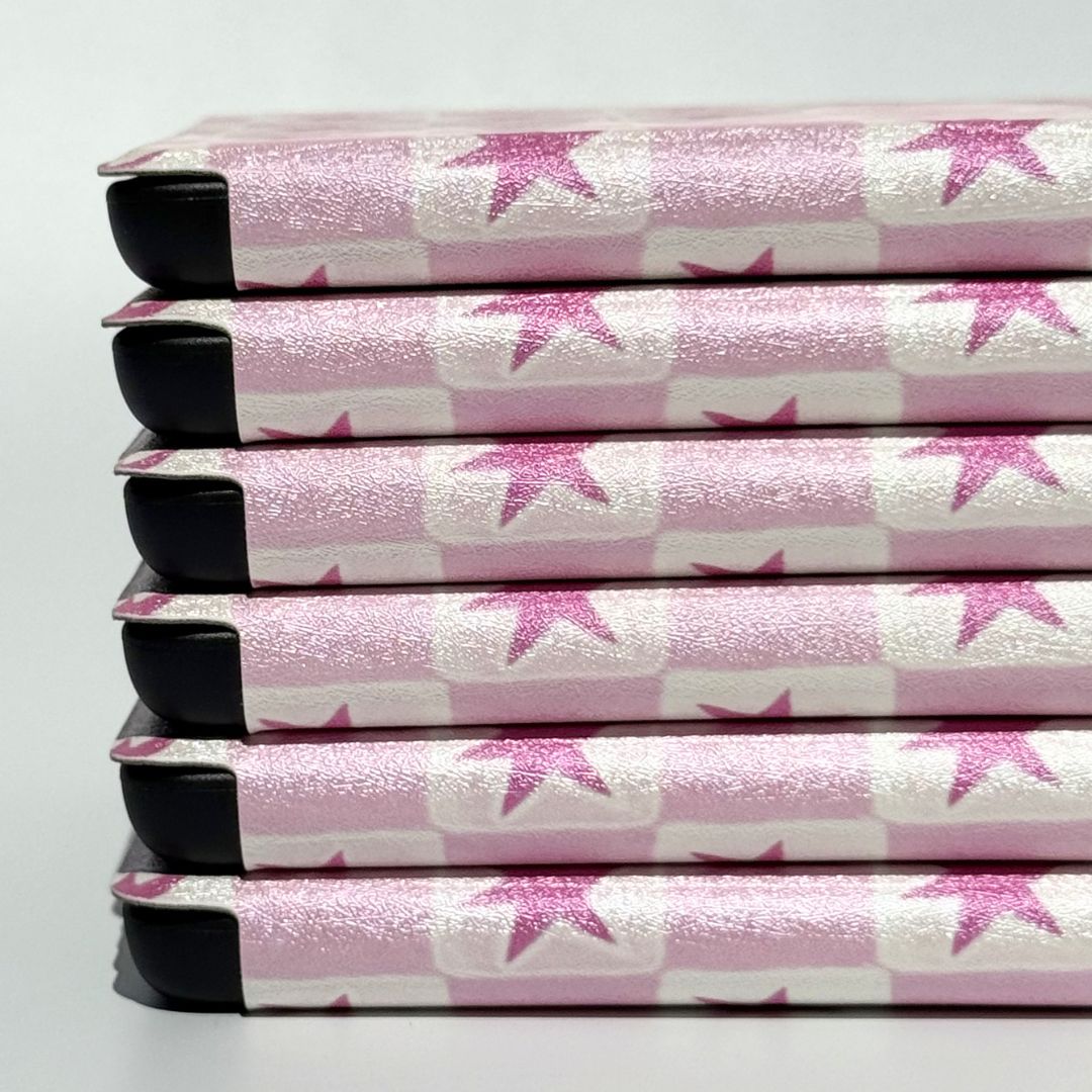 Three pink star Kindle cases overlapping showing Blush Cosmos checkered glitter pattern detail