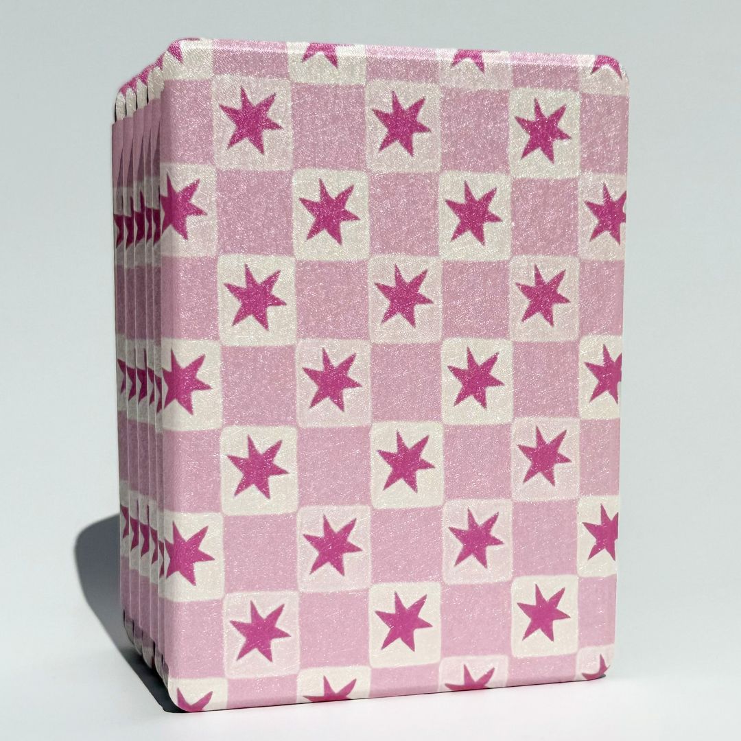 Stack of Blush Cosmos Kindle cases shown from top angle showing pink star shimmer glitter finish