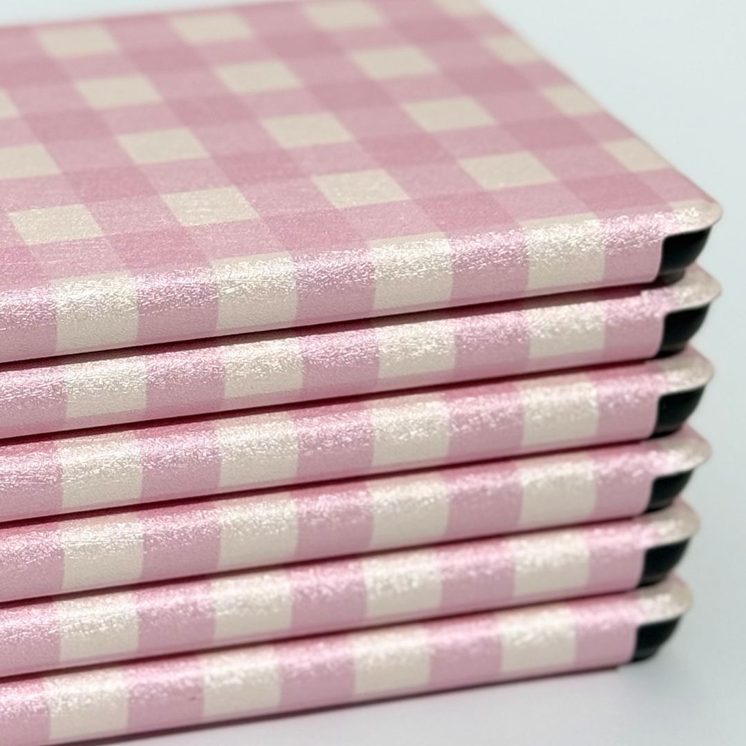  Stack of Blush Lover Kindle cases showing edge profile and pink gingham spine — slim aesthetic design