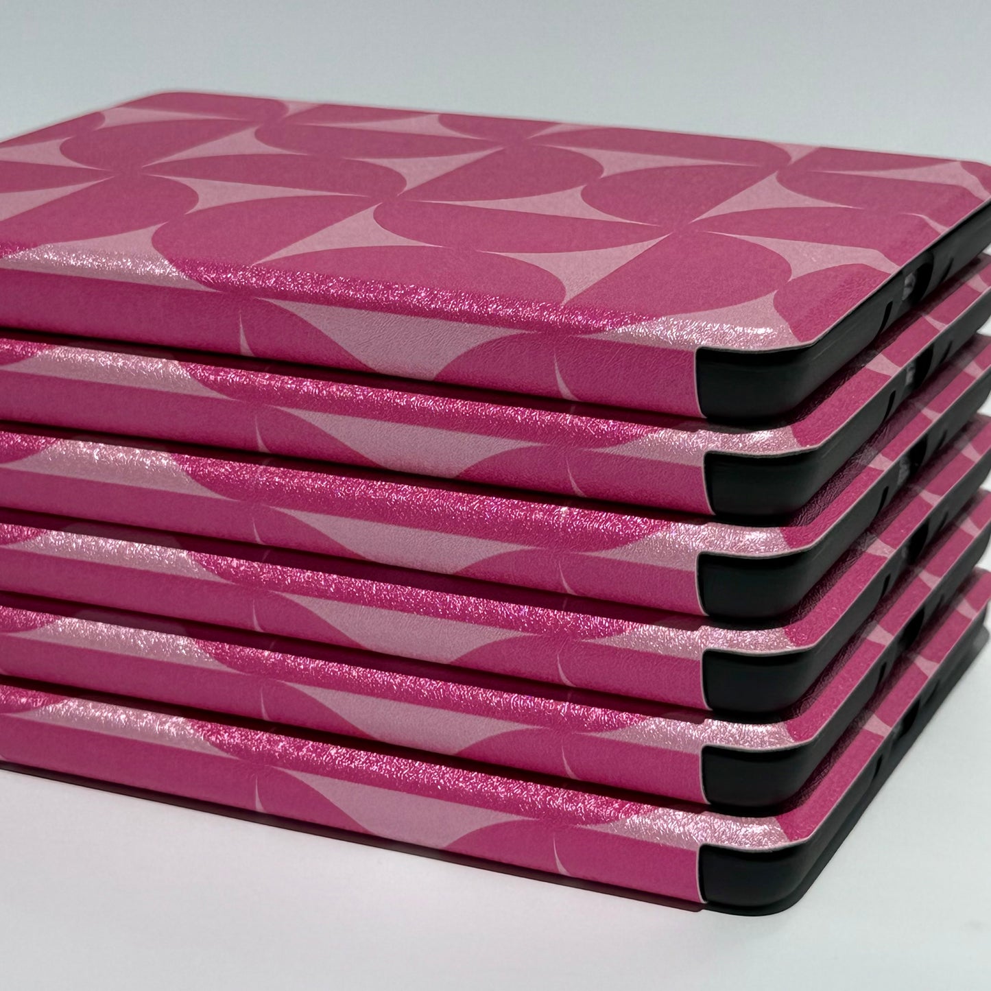 Blushing Moon Kindle Case - close up side view of stack of pink geometric printed cases 