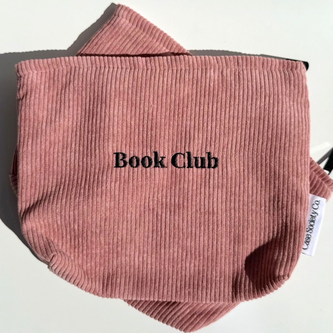 Front of the blush Book Club kindle pouch with embroidered lettering on dusty pink corduroy