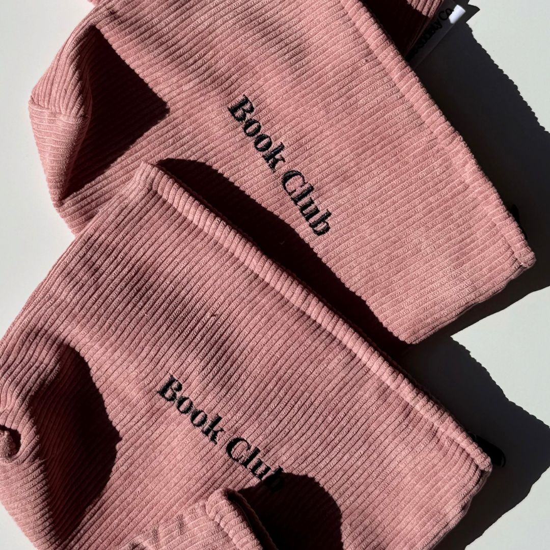 Pair of dusty pink Book Club kindle sleeves overlapping in afternoon light