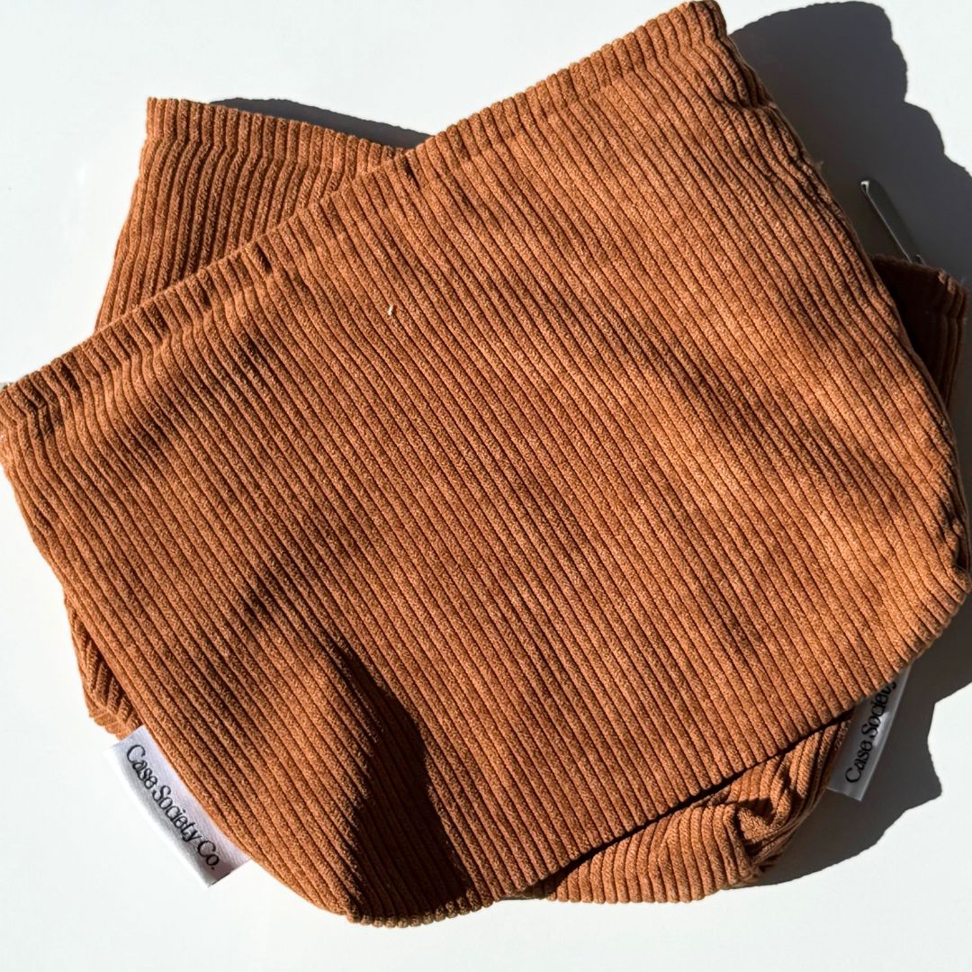 Two mocha kindle sleeves showing the plain corduroy backs and woven Case Society Co labels