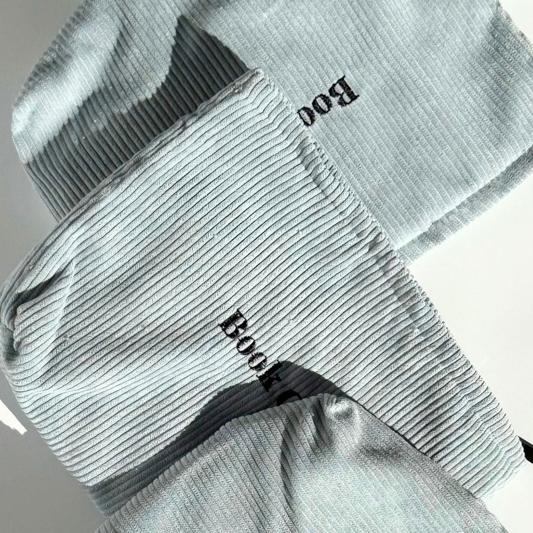 Close view of powder blue corduroy book pouches layered diagonally