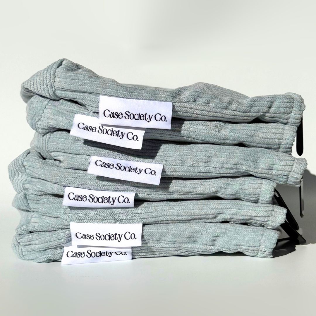 Stack of six folded powder blue corduroy pouches with Case Society Co labels