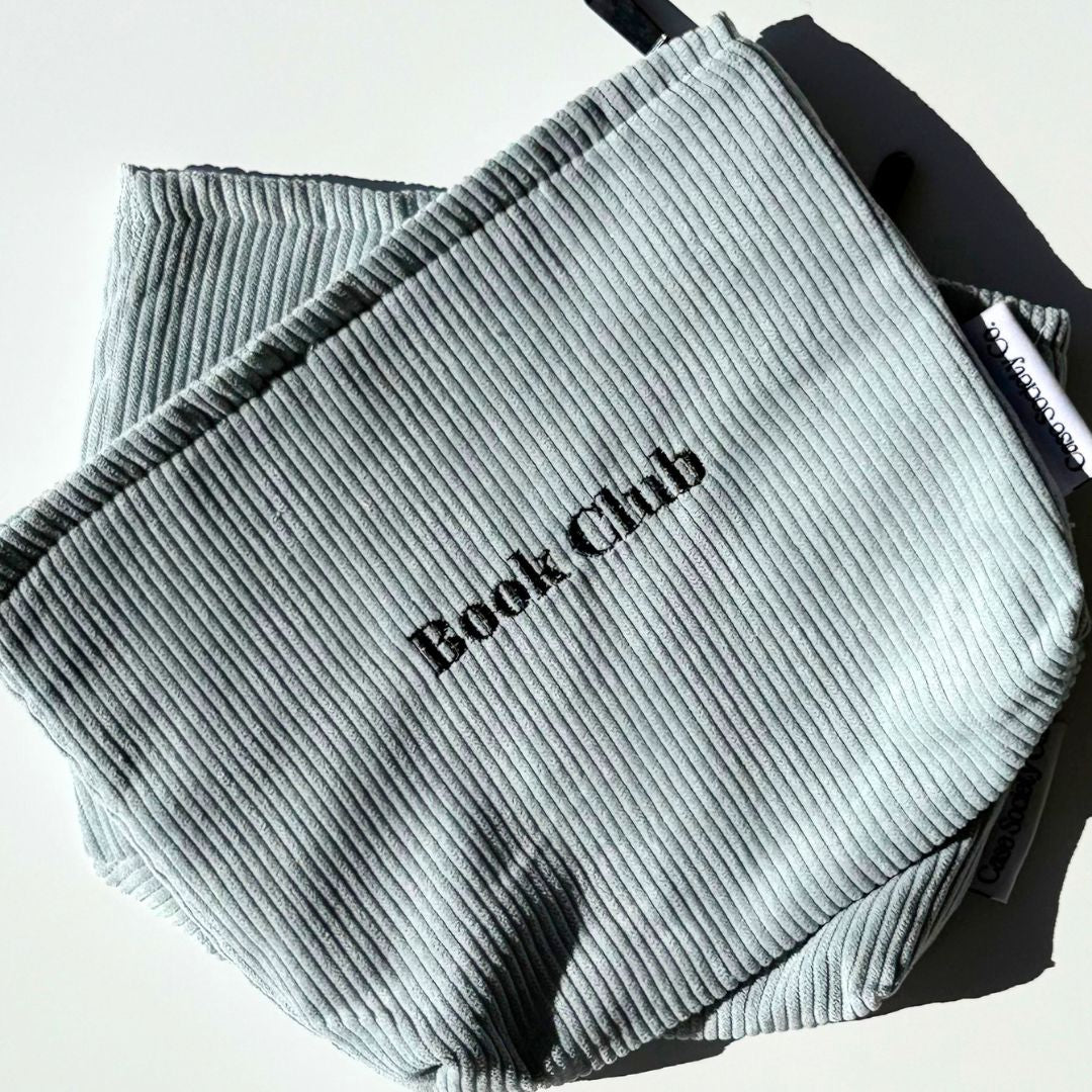 Powder blue corduroy e-reader pouch in sunlight resting on a second pouch, shipped from our Australian shop