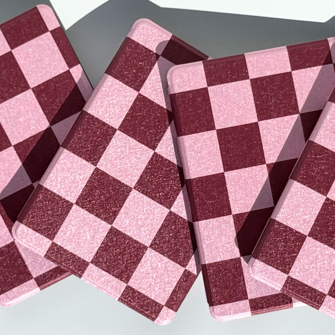 Bordeaux Fiction pink and burgundy checkered Kindle cases propped to show the aesthetic checkerboard — Case Society co AU