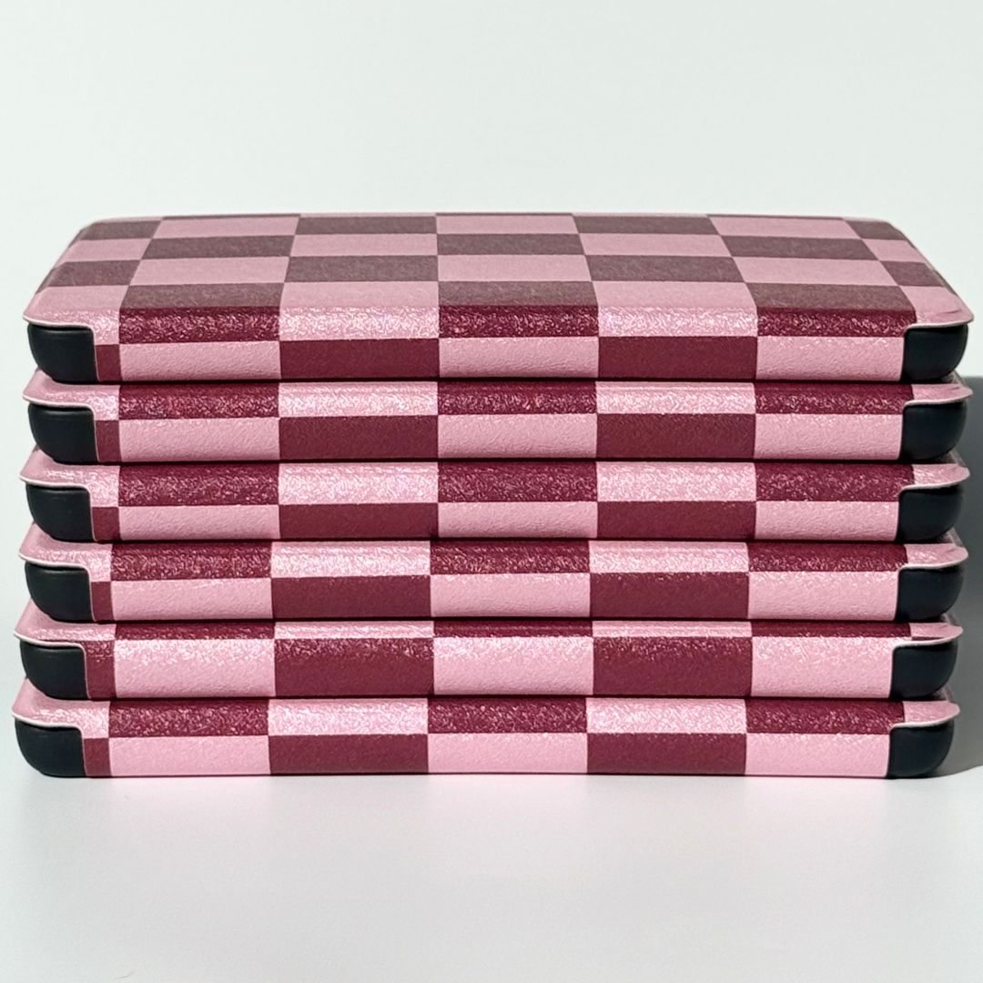Side view of stacked pink checkered Kindle cases highlighting reinforced protective corners — Bordeaux Fiction