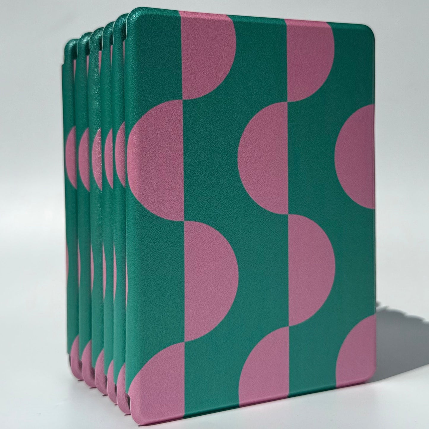 Standing Pink Crescent Kindle cases showing the green and pink arch print