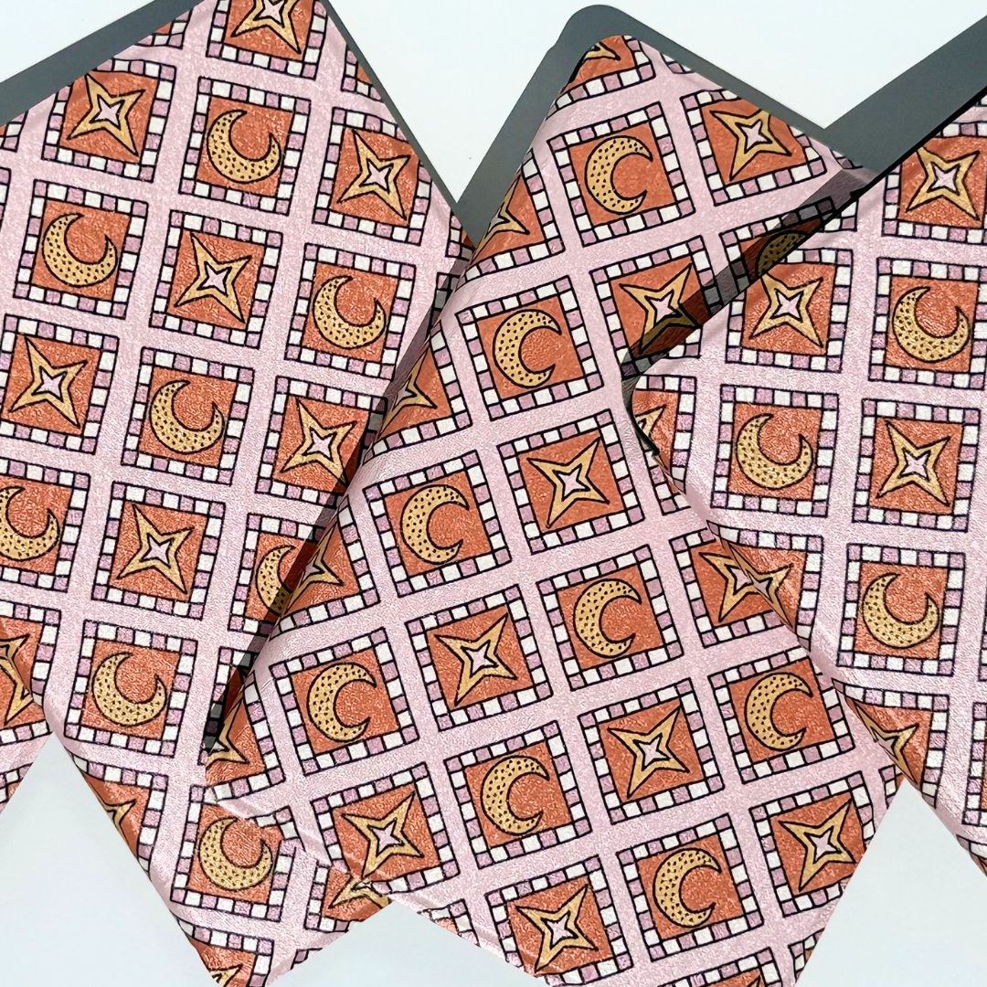 Stack of aesthetic Celestia Kindle cases in a pink celestial pattern