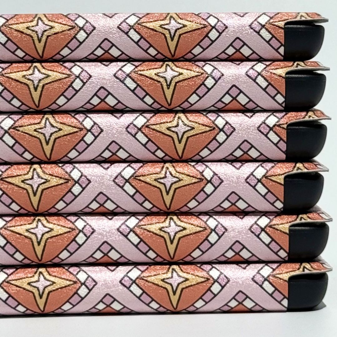 Close-up of the Celestia Kindle case celestial print with moons, stars and pink mosaic detail